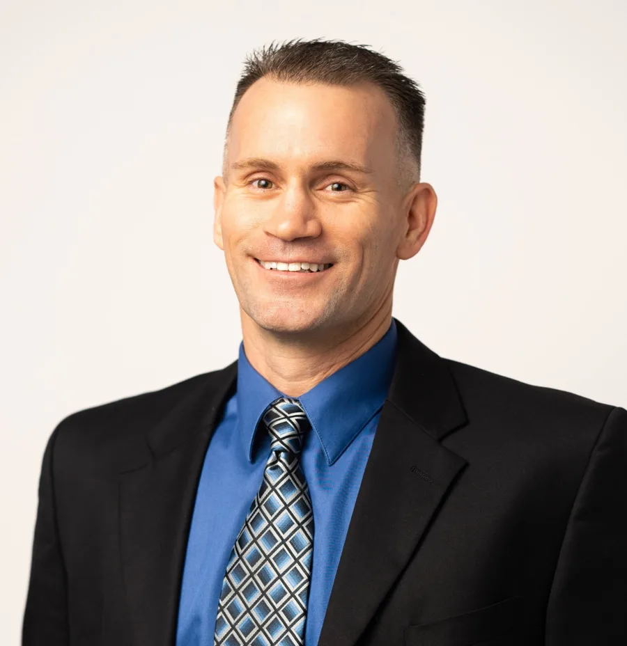 Portrait of attorney Kevin Fowler in a dark suit and blue shirt